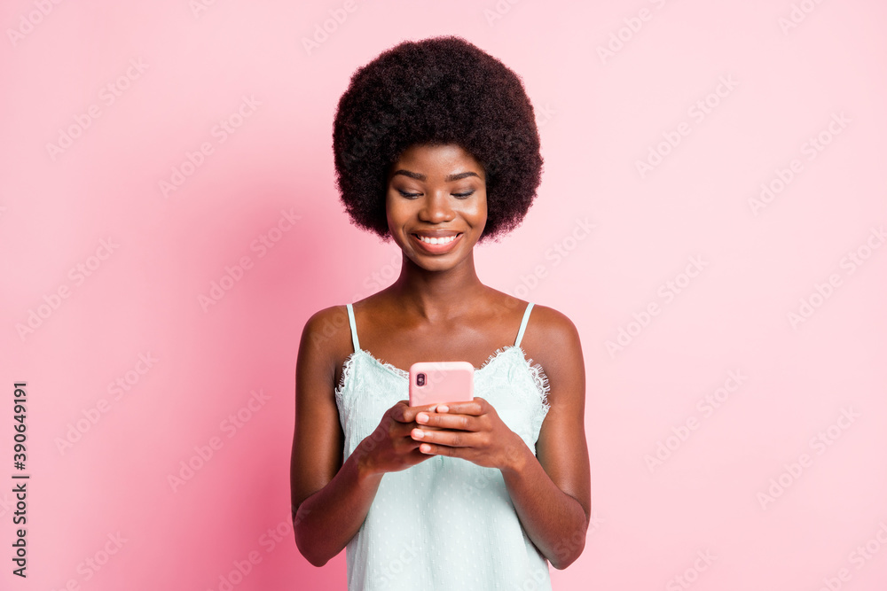 Photo of beautiful brown curly haired girl hold look phone addicted user wear singlet isolated on pink color background Photo of beautiful brown curly haired girl hold look phone addicted user wear singlet isolated on pink color background