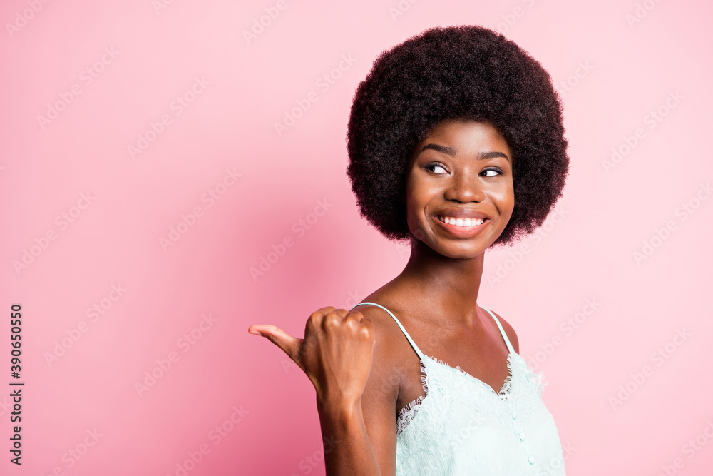 Close up photo of attractive curly hairdo lady direct thumb empty space blue tank-top isolated on pink color background Close up photo of attractive curly hairdo lady direct thumb empty space blue tank-top isolated on pink color background