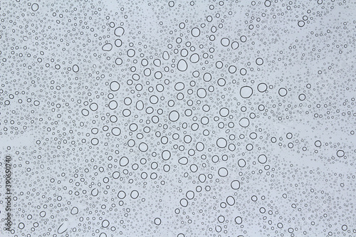 Rain drops on the glass. Abstract background photo. Natural pattern. Water drops on transparent acrylic window sheet. 