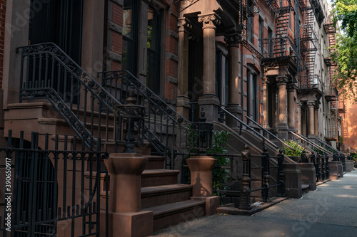 Row of Beautiful Old Brownstone Homes with Staircases along a Sidewalk in Greenwich Village of New York City