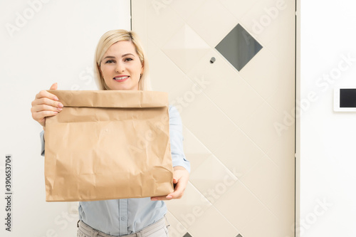Smiling young woman at home received a postal parcel, online shopping and delivery concept