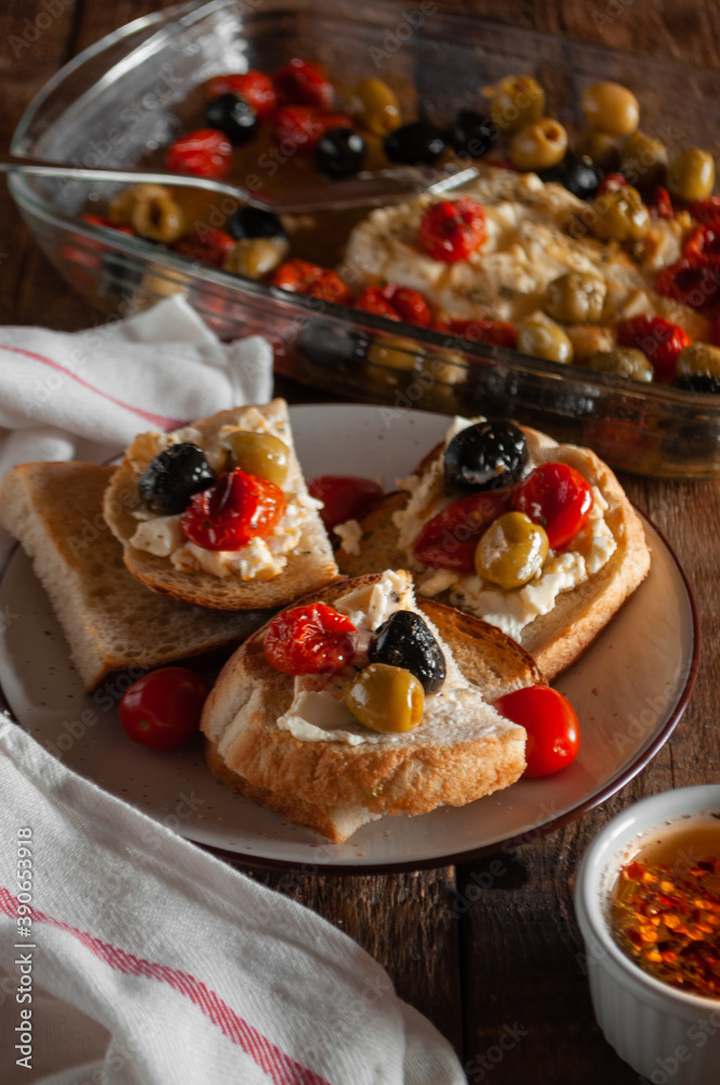 Bruschetta with baked cheese, cherry tomatoes, olives, herbs and butter Bruschetta with baked cheese, cherry tomatoes, olives, herbs and butter