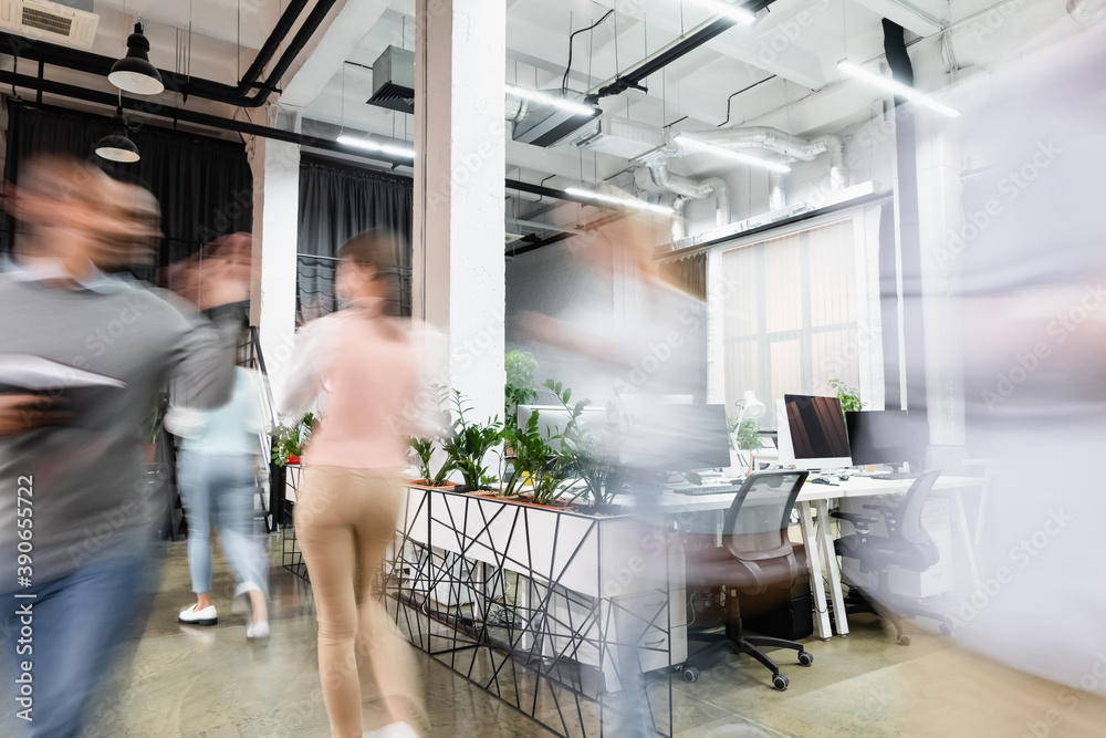 Motion blur of young businesspeople walking in modern office Motion blur of young businesspeople walking in modern office