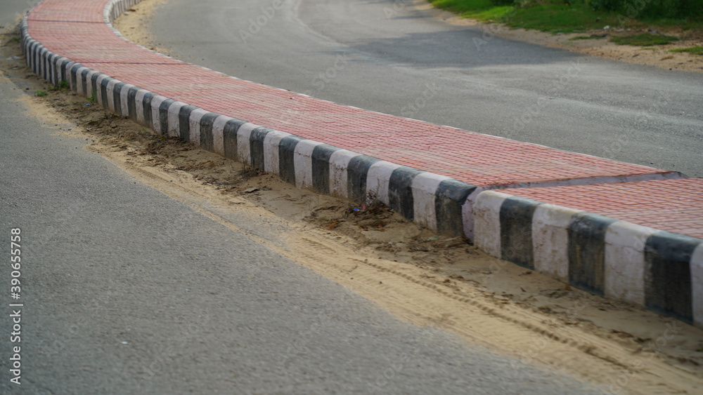 Pink color road divider in a countryside road in India. road with