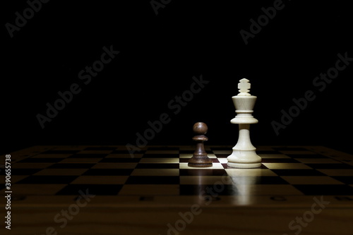 pawn and king are on chessboard on black background