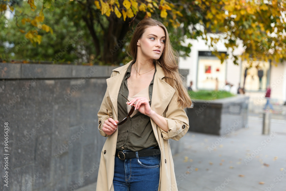 Fototapeta premium young beautiful woman walking in autumn in the center of a big city.