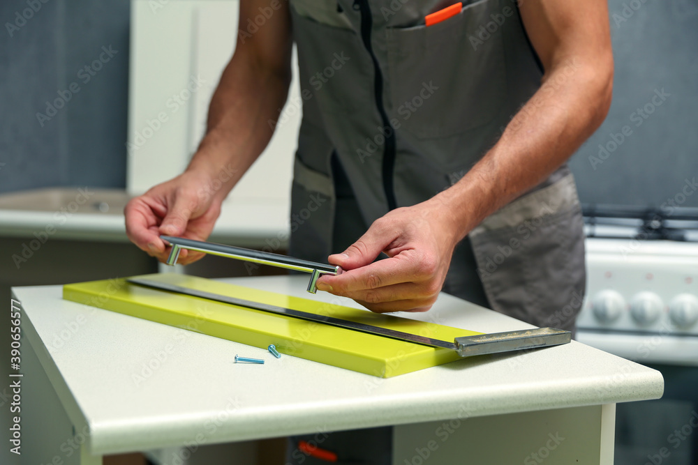 worker assembles furniture in the kitchen. furniture assembly service concept worker assembles furniture in the kitchen. furniture assembly service concept