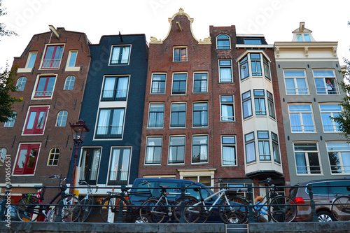 Traditional dutch architecture, facades of houses in Amsterdam, The Netherlands. Bicycle parking in the foreground. Bottom view.