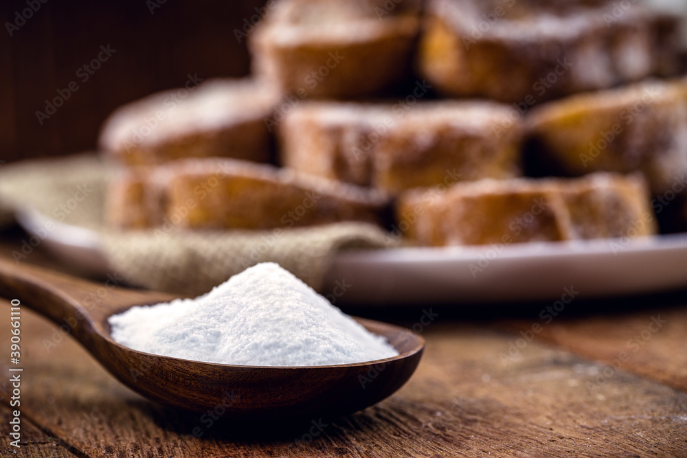 wooden spoon with refined sugar on the side, rustic kitchen concept. Spot focus, toast in the background wooden spoon with refined sugar on the side, rustic kitchen concept. Spot focus, toast in the background