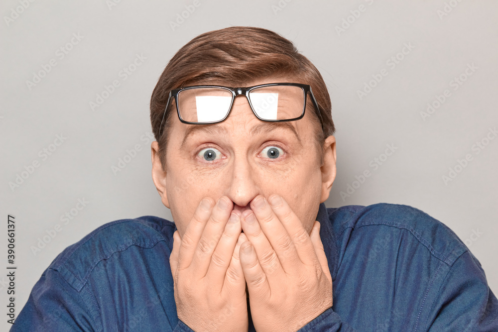 Portrait of shocked frightened mature man covering mouth with hands Portrait of shocked frightened mature man covering mouth with hands