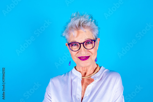 Friendly old woman expressing positive emotions posing isolated smiling at camera