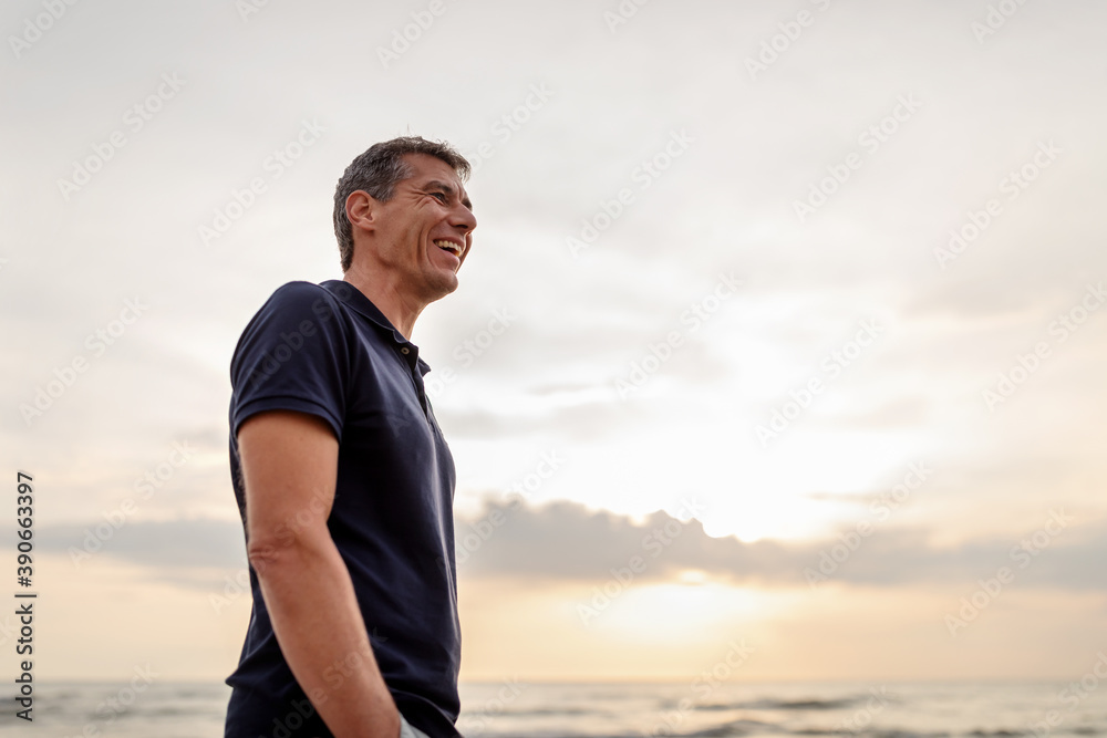 man standing at the beach looking into the distance man standing at the beach looking into the distance