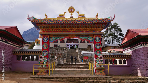 Front view of popular historic monastery (Buddhist gompa) of Thyangboche (Tengboche) with colorful ornate entrance gate, religious decorations and prayer wheels in Khumbu region, Himalayas, Nepal.
