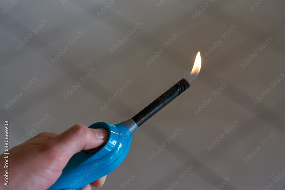 Naklejka premium Aktiviertes Feuerzeug mit kleiner Flamme in Hand