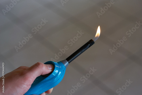 Aktiviertes Feuerzeug mit kleiner Flamme in Hand