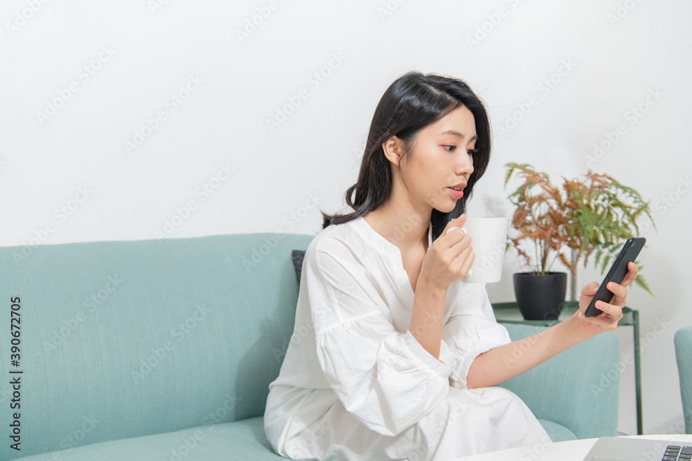 Young Asian female holding smartphone and working with a happy expression Young Asian female holding smartphone and working with a happy expression