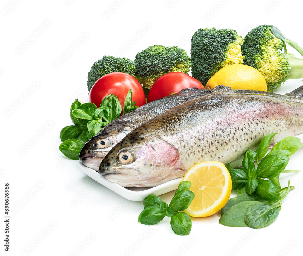 Raw fresh rainbow trout with assortment vegetables and lemons Raw fresh rainbow trout with assortment vegetables and lemons