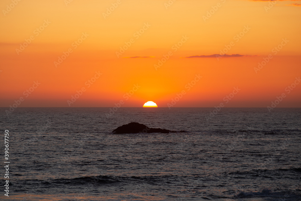 Sunset over the ocean with an island