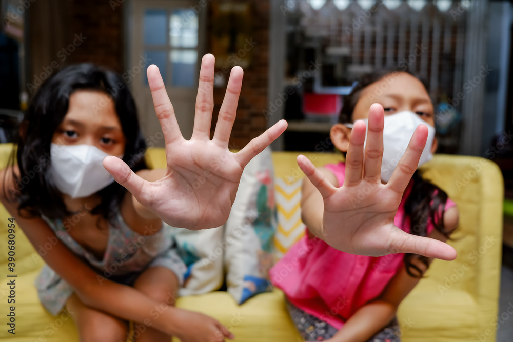 Obraz premium Asian Teenage Girls Wearing Medical Face Mask Making Stopping Signs Gesture with Their Hands