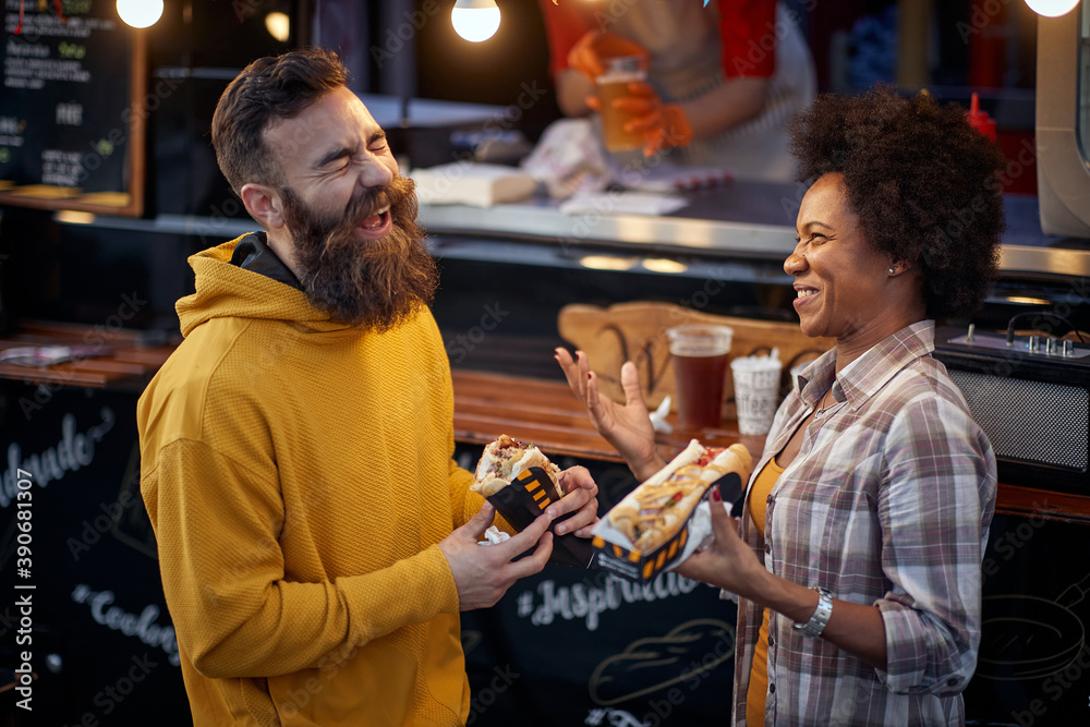 multiethnic couple laughing out loud, having a good time, talking, eating