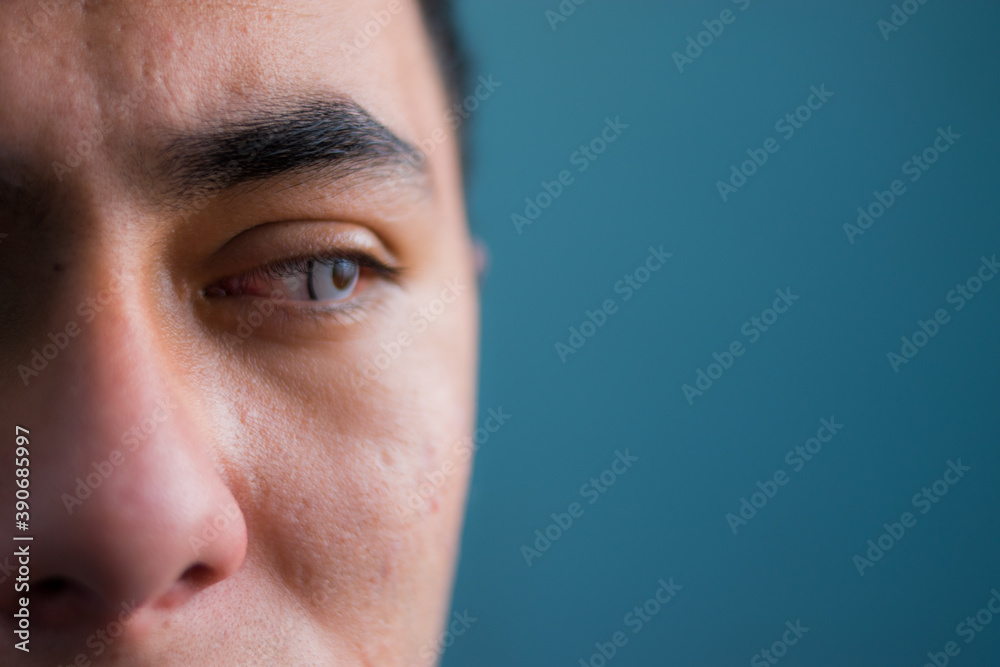 Close up of latin blue eyed man with a blue wall at background