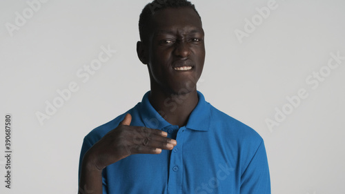 Attractive African American guy biting lip showing cool gesture on camera isolated on white background photo