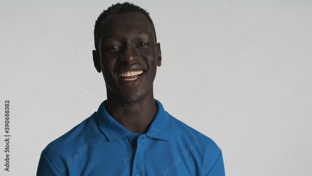 Cheerful African American guy looking happy on camera over white background. Positive expression Cheerful African American guy looking happy on camera over white background. Positive expression