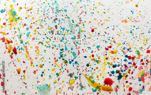 Multicolored paint drops and dots on a light background