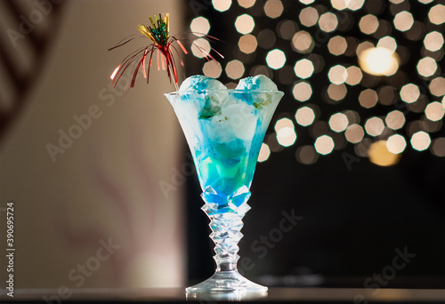 Obraz na płótnie Blue Caterpillar Cocktail. Ice cream balls in a crystal glass are filled with blue liqueur and a transparent straw is decorated in a Happy New Year's style w salonie