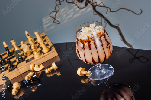 Obraz na płótnie Chocolate and coffee frappe with whipped cream and syrup in the style of Alice in Wonderland with chess and reflections w salonie