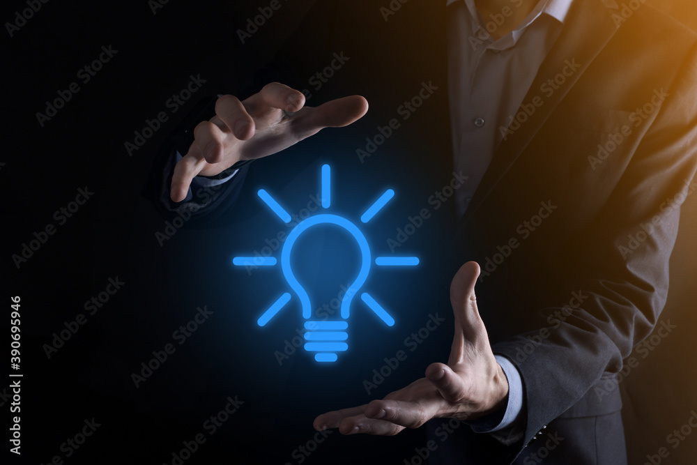 Businessman in a suit with a light bulb in his hands. Holds a glowing ...