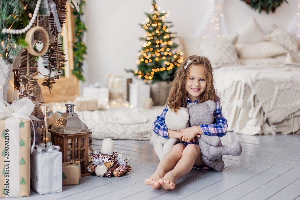 little beautiful cute girl playing on christmas morning in the living room. Happy childhood pleasure moments of joy. Lifestyle. Xmas mood. A child plays in new Year. Cosy living room. little beautiful cute girl playing on christmas morning in the living room. Happy childhood pleasure moments of joy. Lifestyle. Xmas mood. A child plays in new Year. Cosy living room.