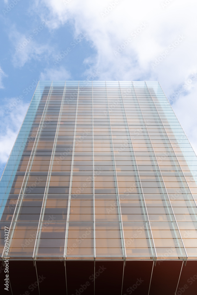 windows with reflection of clouds and blue sky in industrial and colorful business buildings