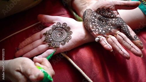 Top down video of a woman copying the mehndi henna tattoo from one hand to the other in preparation of the hindu festival of teej, karwachauth, diwali dussera or a marriage function photo