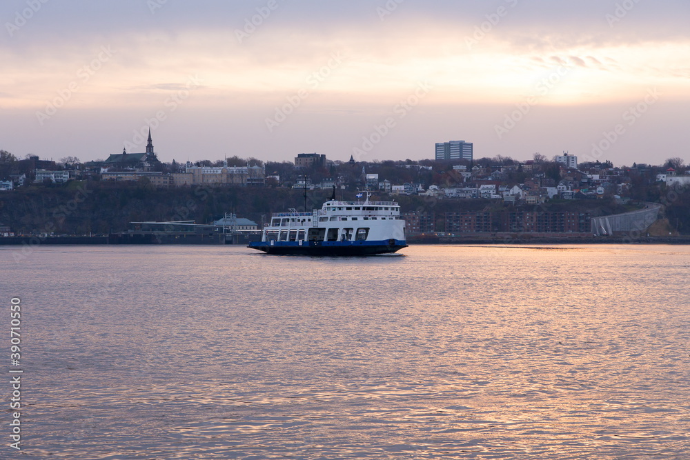 The ferry across the St. Lawrence River leaving the Levis terminal during a hazy Fall dawn seen from Quebec City, Quebec, Canada