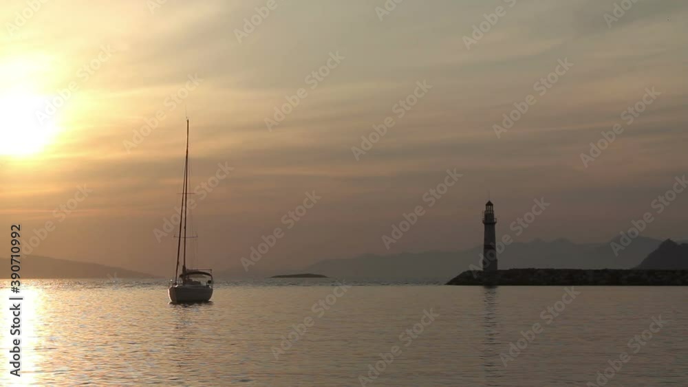 Seascape at sunset. Lighthouse on the coast. Seaside town of Turgutreis and spectacular sunsets