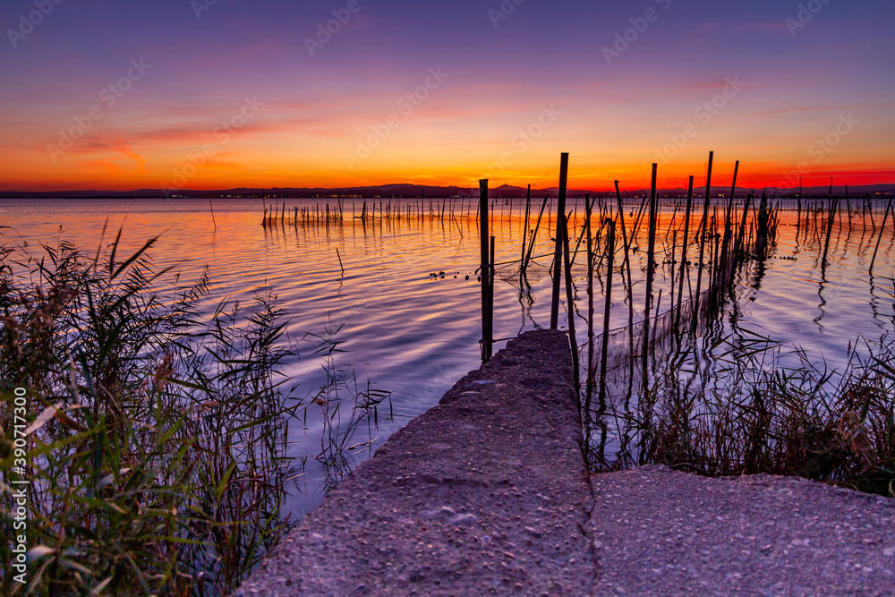 Beautiful sunset rom La Albufera in Valencia (Spain). You can see the traditional fishing gear used by local fishermen to obtain eels and other fish.