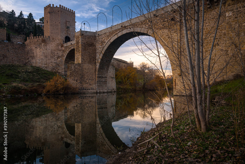 The famous Alcantara bridge over Tagus river in the medieval city of Toledo at sunset, Spain