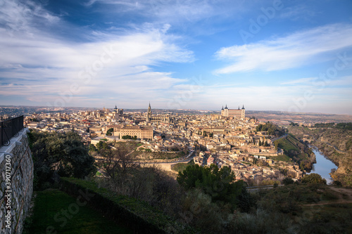 Panoramic view of the old town of the monumental city of Toledo from a balcony with a blue sky with clouds, Spain