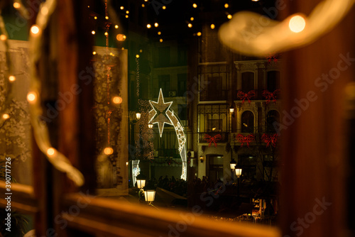 Christmas lights in the streets of the old town of Toledo city through a window, Spain