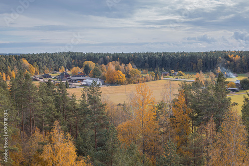 Aerial view at a beautiful autumn landscape with a farm and fields.