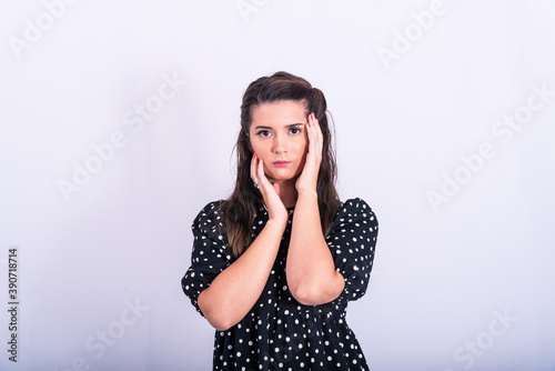 a beautiful young girl posing in a short black and white dress on a white background