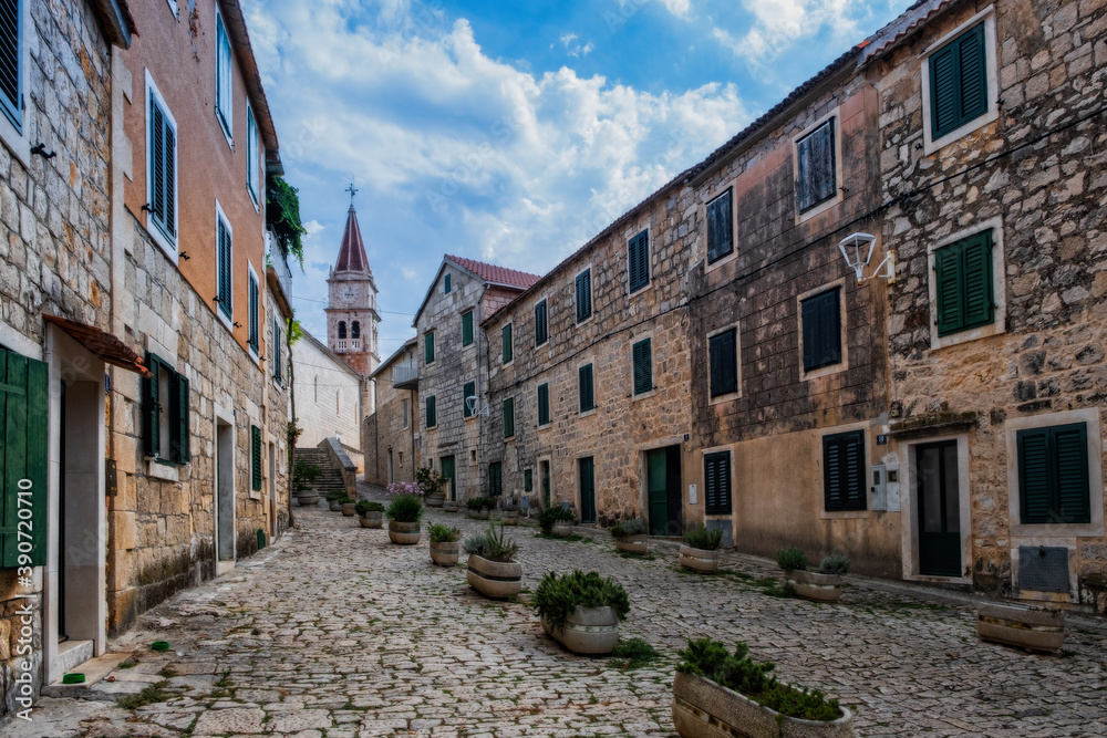 Street with typical stone houses in Postira old town, Brac island, Croatia. August 2020