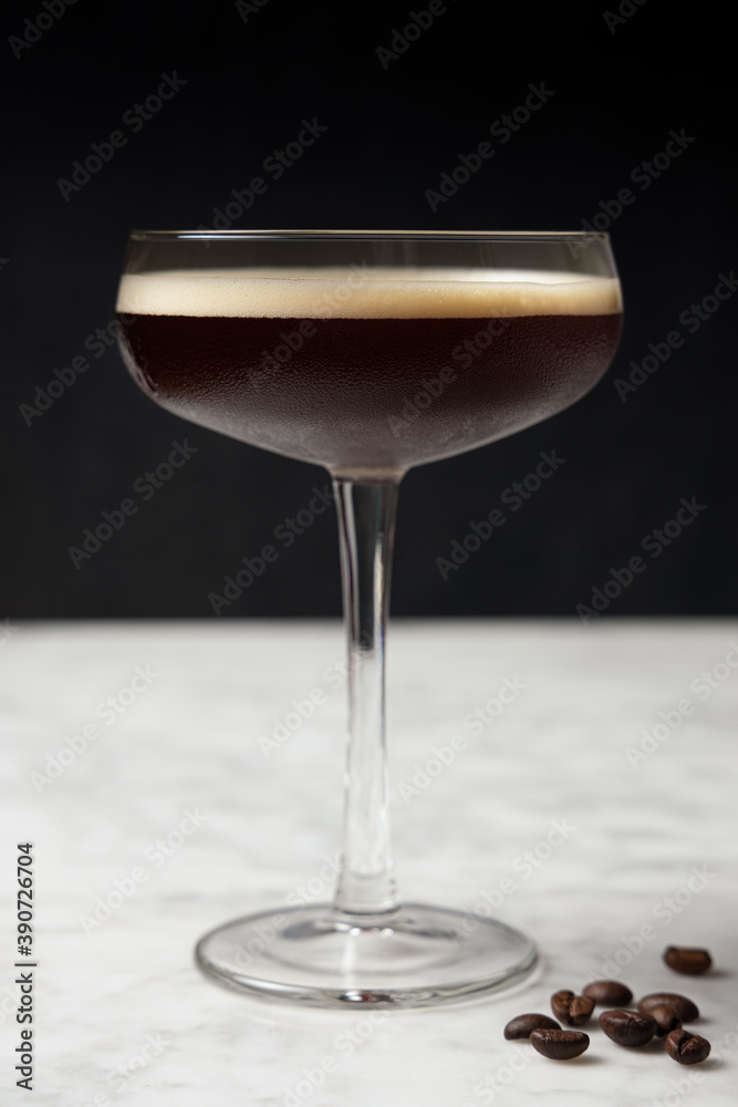 Front view of an Espresso Martini on a marble table. Coffee beans decoration