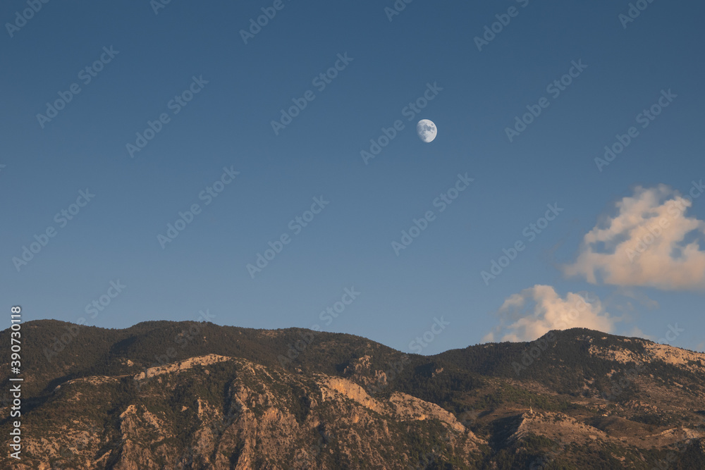 Skyline Silhouette of the Μoon Rising over a tall mountain with trees. Skyline Silhouette of the Μoon Rising over a tall mountain with trees.