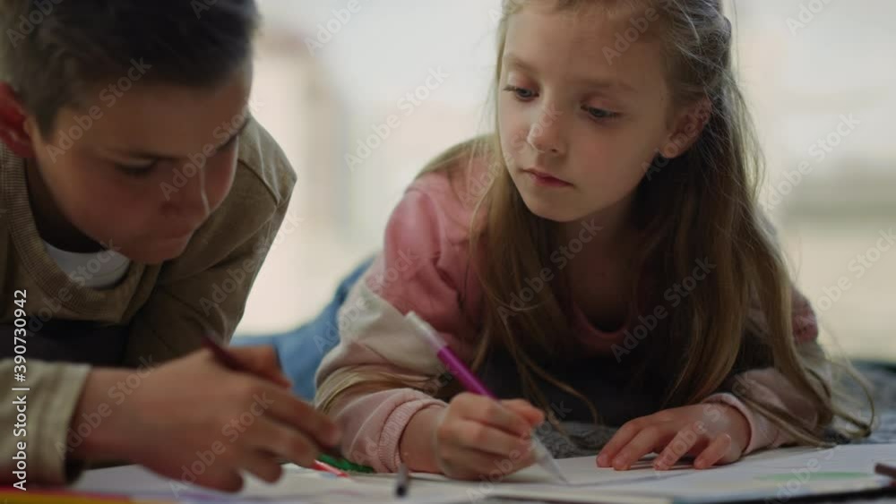 Children painting with colored pencils at home. Siblings drawing on sketchbooks. Children painting with colored pencils at home. Siblings drawing on sketchbooks.