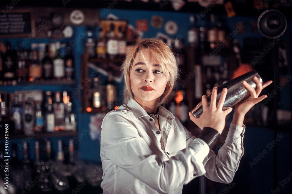Girl bartender concocts a cocktail at the bar