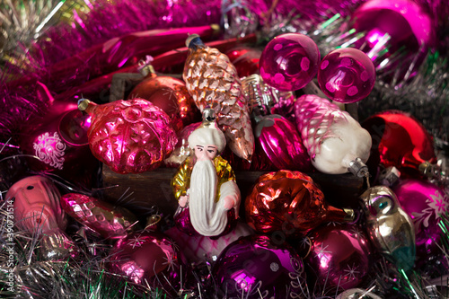 Vintage Christmas toys from the USSR times in the form of cones, snowflakes, the bearded old man Hottabych, mushrooms and others. pink toys on a Christmas tree in a wooden box, silver tinsel.  photo