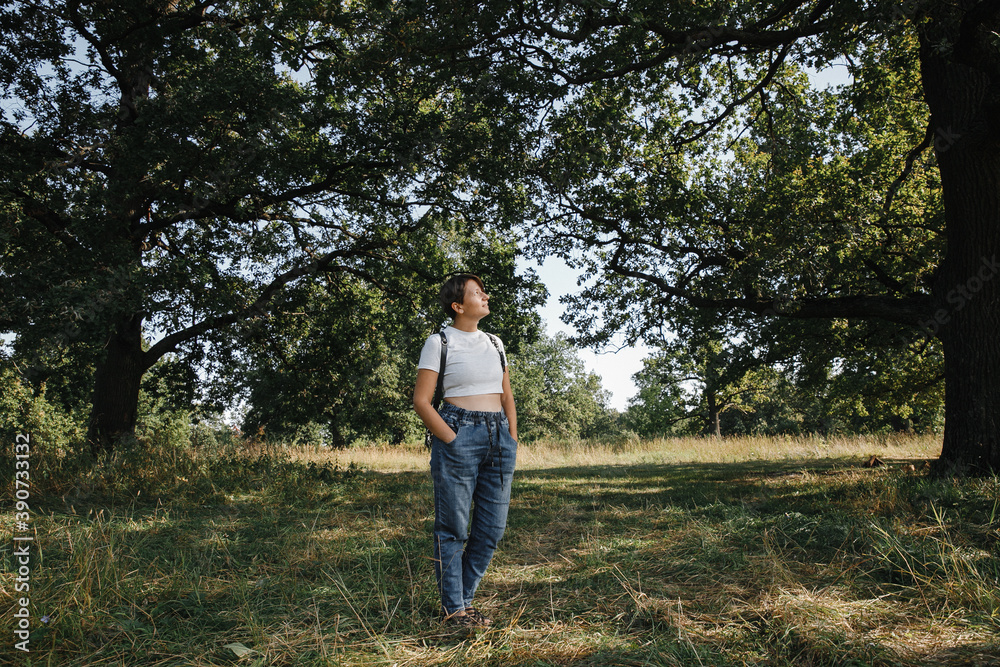 Leather belts. Professional photographer's unloading system on the back in the work. Portrait of the photographer, a woman stands with her face and looks to the left with a camera, uniform