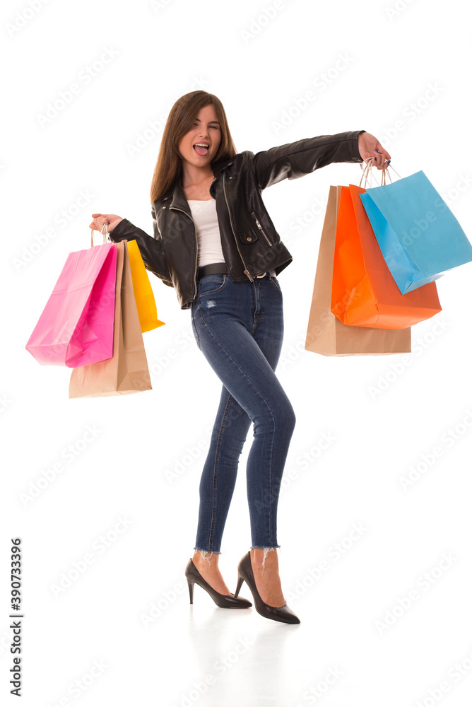Girl after the sale stands on a white background with purchases. Girl shows her tongue and holds purchases in her hands. 